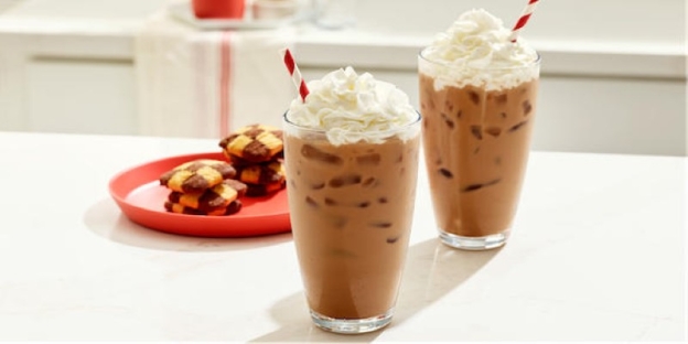 Two glasses of chocolate milkshakes with whipped cream and straws AI-generated content may be incorrect.